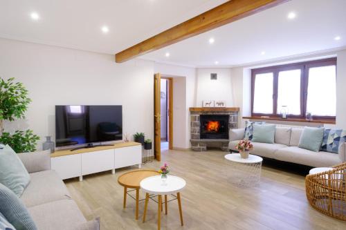 a living room with a couch and a tv at La Era de Casaus in Gavín