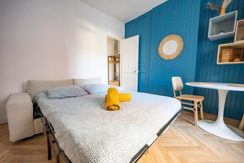 - une chambre avec un lit avec un animal rembourré jaune dans l'établissement La brise marine, au Havre