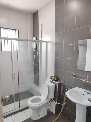 a bathroom with a shower and a toilet and a sink at Casa Margosa Homestay in Ipoh