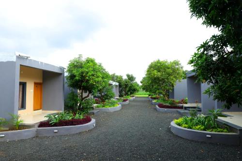 a row of houses with trees and plants at Iravati Resort in Sasan Gir