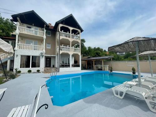 een grote villa met een zwembad en stoelen bij Villa Durmic in Sarajevo