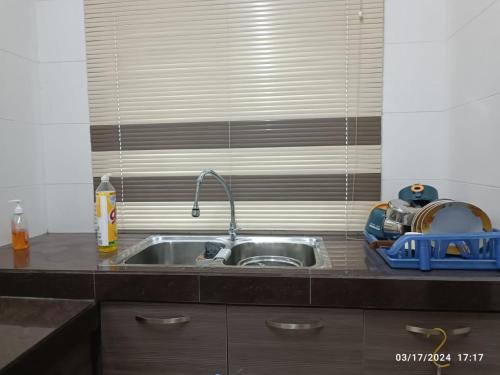a kitchen sink with a faucet next to a window at Casa Margosa Homestay in Ipoh