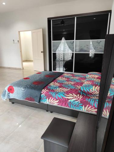a bedroom with a large bed with a colorful comforter at Casa Margosa Homestay in Ipoh