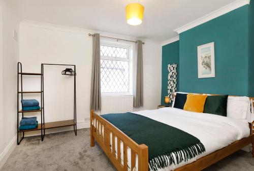 a bedroom with a bed and a blue wall at House in Malton in Norton