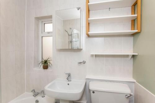 a white bathroom with a toilet and a sink at House in Malton in Norton