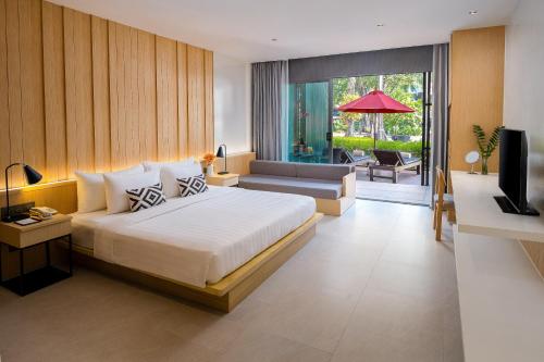 Ramada Resort by Wyndham Khao Lak في خاو لاك: غرفة نوم مع سرير وغرفة معيشة