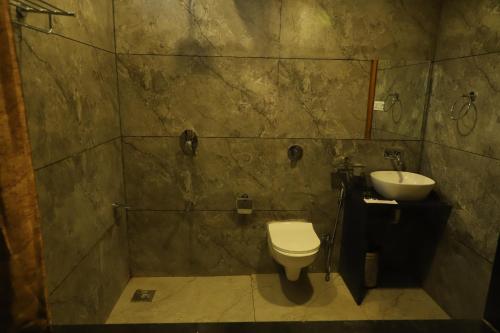 a bathroom with a toilet and a sink at Iravati Resort in Sasan Gir