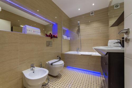 a bathroom with a toilet and a sink and a tub at The Queen Luxury Apartments - Villa Carlotta in Luxembourg