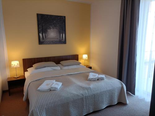 1 dormitorio con 1 cama con 2 toallas en Hotel Eminent, en Stupava