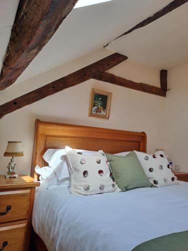 Schlafzimmer mit einem Bett mit weißer Bettwäsche und Kissen in der Unterkunft Chateau de Chambres Mont St Michel in Saint-James