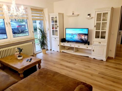 a living room with a flat screen tv and a table at Schöne Ferienwohnung im Schwarzwald in Bad Herrenalb