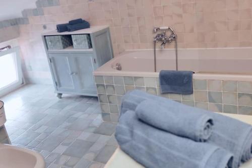 La salle de bains est pourvue d'une baignoire et d'une serviette bleue. dans l'établissement MADDy's HOUSE, à La Maddalena