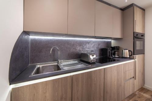 a kitchen with a sink and a microwave at The Queen Luxury Apartments - Villa Carlotta in Luxembourg