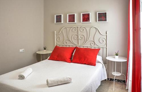 a bedroom with a white bed with red pillows at Ritual Sevilla, piedra preciosa in Seville