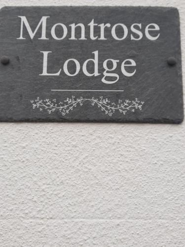a sign that says monroe lodge on a wall at montrose lodge in Cheltenham