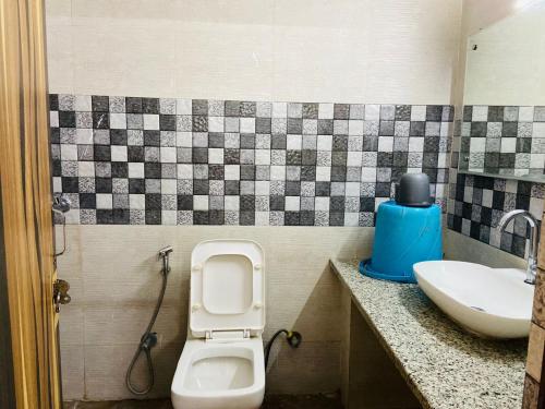 a bathroom with a toilet and a sink at Abuzz Oxfordcaps Agrasen Boys Hostel, Dehradun in Dehradun