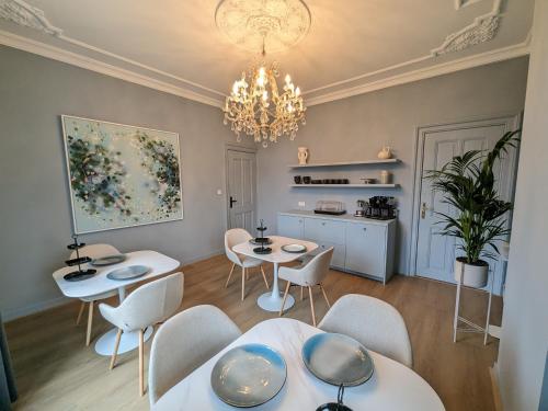 a dining room with tables and chairs and a chandelier at B&B Villa van Voss in Etten-Leur