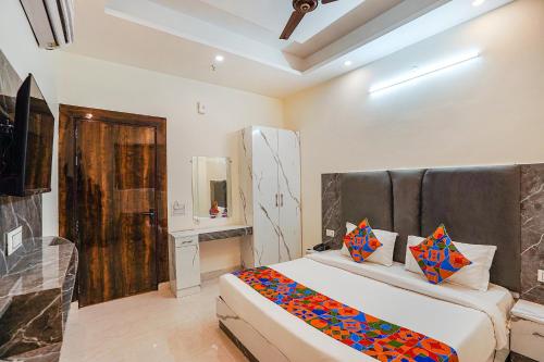 um quarto com uma cama grande e um espelho em FabExpress Red Diamond em Ghaziabad