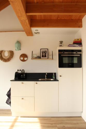 a kitchen with white cabinets and an oven at Noxem b&b in Boesingheliede