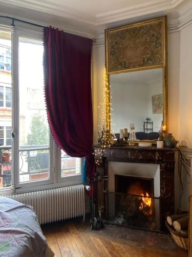 un salon avec une cheminée et un miroir dans l'établissement Jolie appartement 4 pièces, à Montreuil