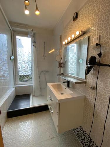 une salle de bain avec un lavabo, un miroir et une fenêtre dans l'établissement Jolie appartement 4 pièces, à Montreuil