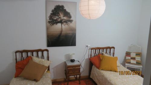 1 dormitorio con 2 camas y una foto en la pared en Casa Rural, paz y naturaleza., 