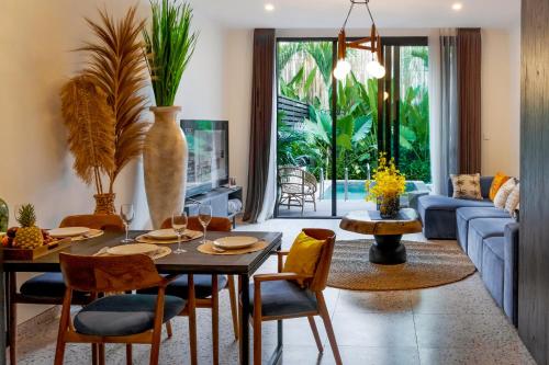 sala de estar con mesa, sillas y sofá en Sunny Village Batu Bolong, en Canggu