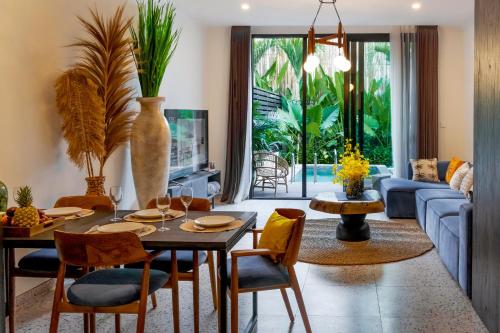 a living room with a table and chairs and a couch at Sunny Village Batu Bolong in Canggu
