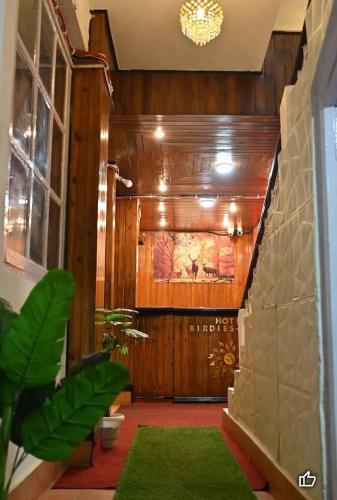 een grote lobby met een groen tapijt voor een deur bij Hotel Birdie's Nest in Darjeeling