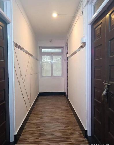 een lege hal met een deur en een raam bij Hotel Birdie's Nest in Darjeeling