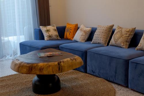 a blue couch with pillows and a wooden coffee table at Sunny Village Batu Bolong in Canggu