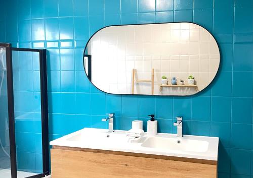 a bathroom with a white sink and a mirror at Appart Brussels EXPO & ATOMIUM in Grimbergen