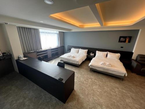 um quarto de hotel com duas camas e um sofá em Chill Place ll em Zhudong