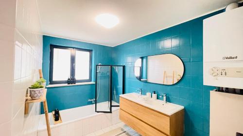 uma casa de banho azul com um lavatório e um espelho em Appart Brussels Atomium&Expo em Grimbergen