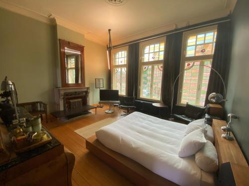 een slaapkamer met een bed in een kamer met ramen bij Lunatree in Mechelen