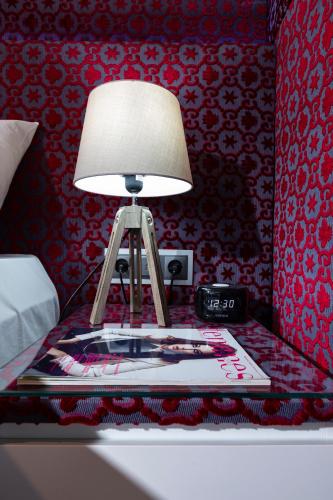 a lamp on a table in a bedroom at The Queen Luxury Apartments - Villa Carlotta in Luxembourg