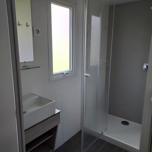 a bathroom with a glass shower and a sink at Camping Onlycamp Le Petit Port in Châtel-Censoir