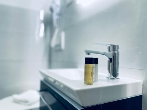 een wastafel in de badkamer met een fles crème erop bij Astraluxe in Fažana