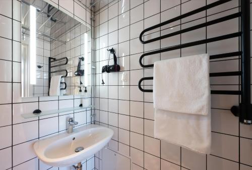 a white bathroom with a sink and a mirror at StayBliss Haven Kakumäe in Tallinn