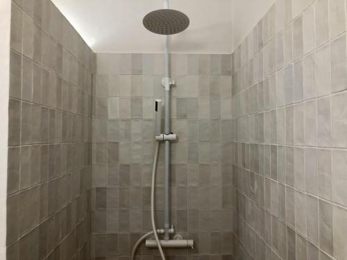 eine Dusche mit Duschkopf in einem gefliesten Badezimmer in der Unterkunft CABIONI - casa adosada con piscina comunitaria, cerca de la playa de Grifeu. - ES-228-39 in Llança