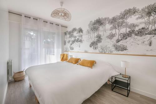 une chambre avec un grand lit blanc et une fenêtre dans l'établissement Détente et évasion à la Baule-Escoublac, à La Baule
