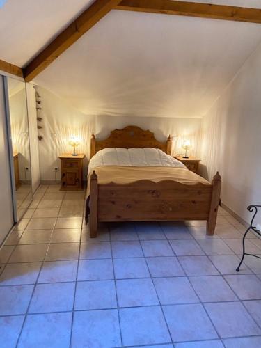 - une chambre avec un lit en bois et 2 tables de nuit dans l'établissement La Roseliere, à Sévrier
