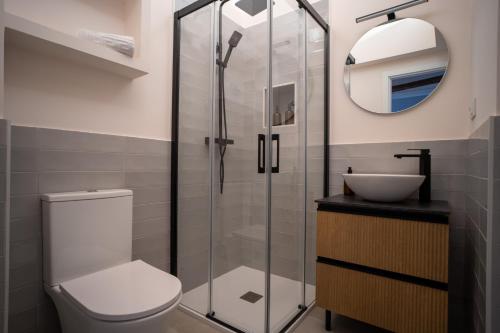 a bathroom with a toilet and a glass shower at El Secreto de Chirinos in Úbeda