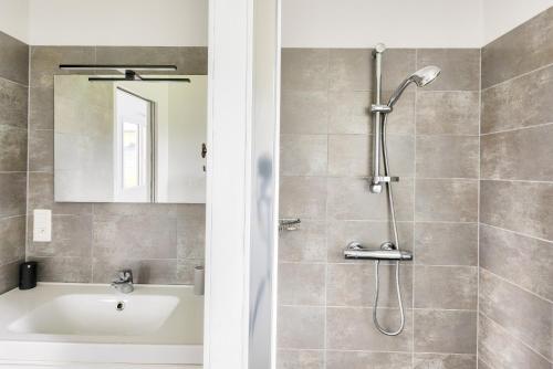 La salle de bains est pourvue d'une douche, d'une baignoire et d'un lavabo. dans l'établissement Vue mer - Maison neuve avec jardin, à Erquy