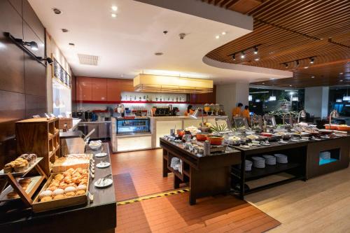 a large kitchen with a buffet in a restaurant at Sathorn Vista, Bangkok - Marriott Executive Apartments in Bangkok