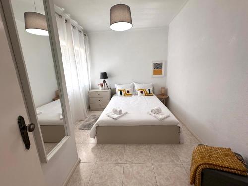 a small bedroom with a bed and a mirror at Wave Beach House in Vila do Conde