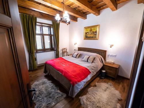 ein Schlafzimmer mit einem Bett mit einer roten Decke in der Unterkunft Harghita Traditional House in Szèkelydobò