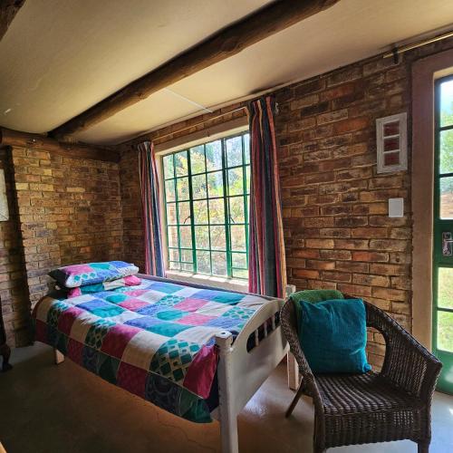 a bedroom with a bed and a window and a chair at Villa Dachie in Rayton