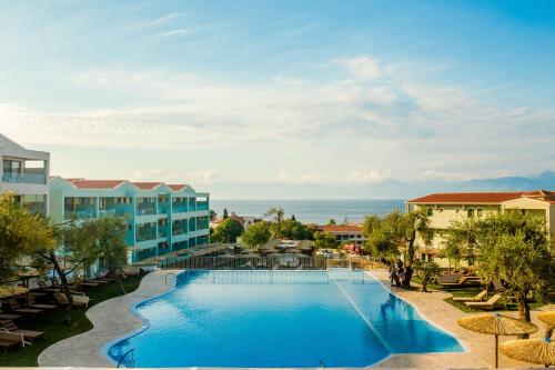 uma imagem de uma piscina num resort em Robolla Beach Aparthotel em Roda