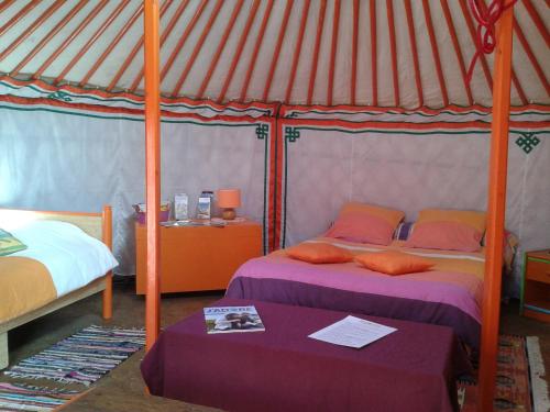 a bedroom with two beds in a yurt at Yourte et nature in Magnien